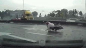 Trượt ngã xuống đường, người đàn ông thoát chết trước đầu xe tải