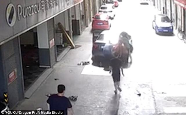 bo bat can lai xe can qua nguoi dua con dang choi truoc cua gara o to - 3